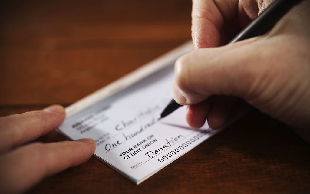 Writing a donation check to a charitable organization